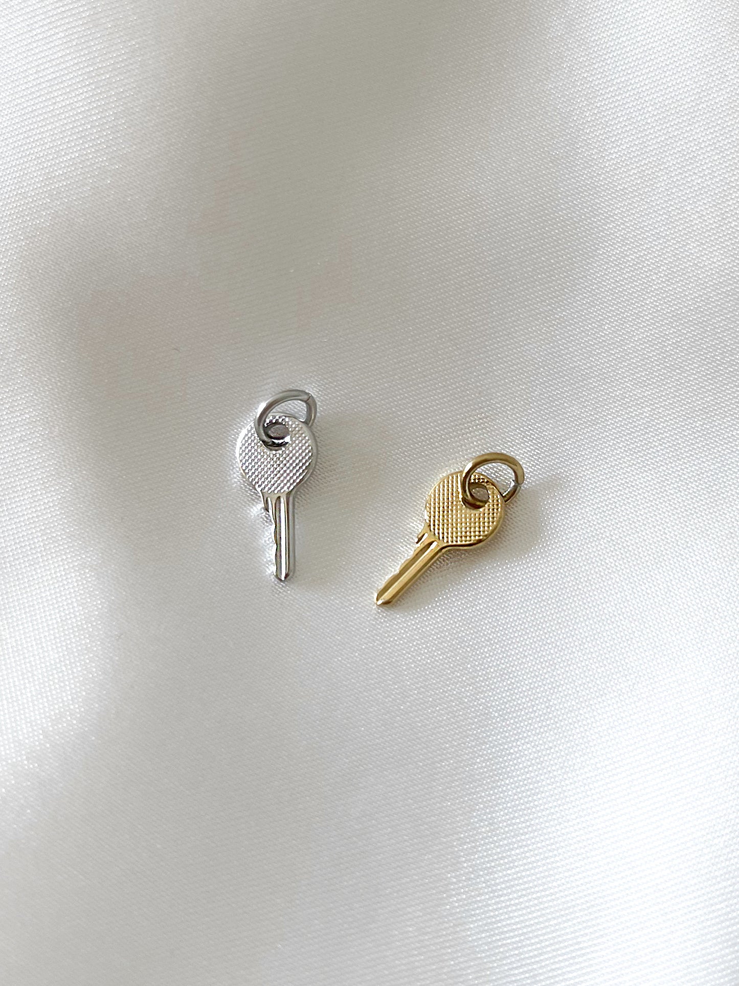 Unser Charm Anhänger ''Key'' in Form eines Schlüssels ist ein elegantes Accessoire, das jedem Schmuckstück eine besondere Bedeutung verleiht.  Hergestellt aus robustem Edelstahl und mit 18k Gold vergoldet, ist der Anhänger wasserfest und nickelfrei.  Er kann an all unsere Armbänder oder Ketten angebracht werden und verleiht deinem Look eine stilvolle und persönliche Note.