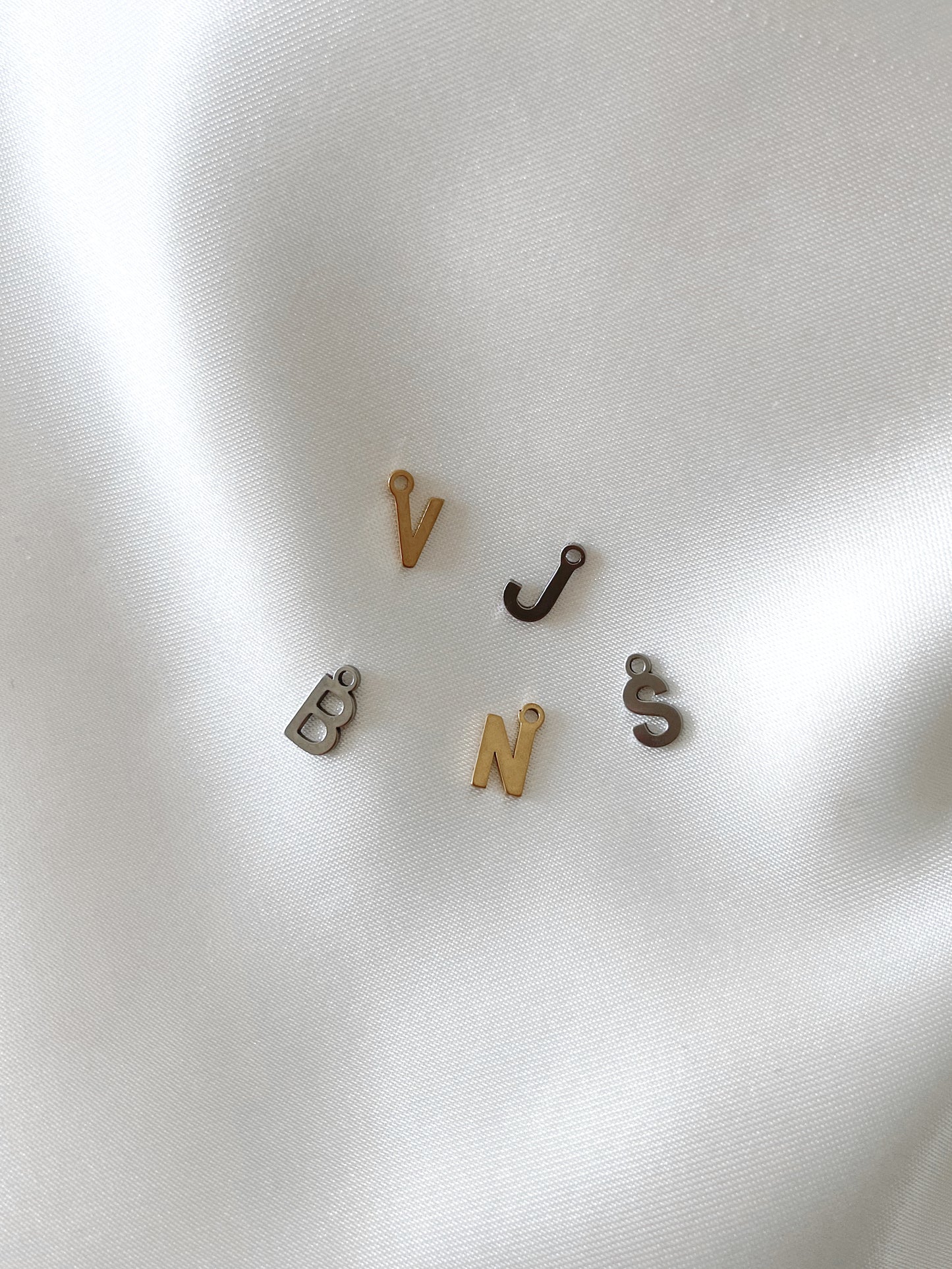 Unser schlichter Buchstaben Charm Anhänger ist ideal, um deinen Schmuck zu personalisieren.  Der Anhänger, aus Edelstahl gefertigt und mit 18k Gold vergoldet, ist wasserfest und nickelfrei, wodurch er langlebig und hautfreundlich ist.  Du kannst ihn an all unsere Armbänder oder Ketten anbringen, um dein Schmuckstück individuell zu gestalten.