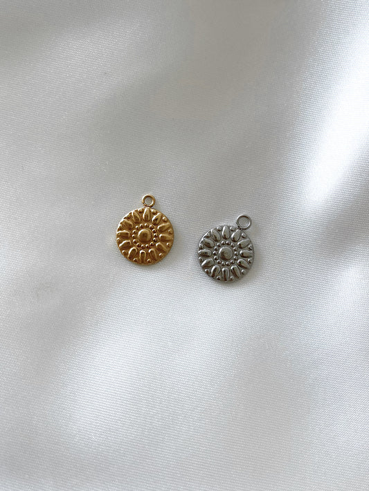 Unser runder Charm Anhänger ''Mandala'' mit einem kunstvollen Mandala Design verleiht deinem Schmuck eine einzigartige Note.  Hergestellt aus hochwertigem Edelstahl und 18k vergoldet, ist dieser Anhänger nicht nur ein Hingucker, sondern auch wasserfest und nickelfrei.  Du kannst ihn an all unsere Armbänder oder Ketten anbringen, um deinen Schmuckstein individuell zu gestalten und deinem Look eine spirituelle Eleganz zu verleihen.