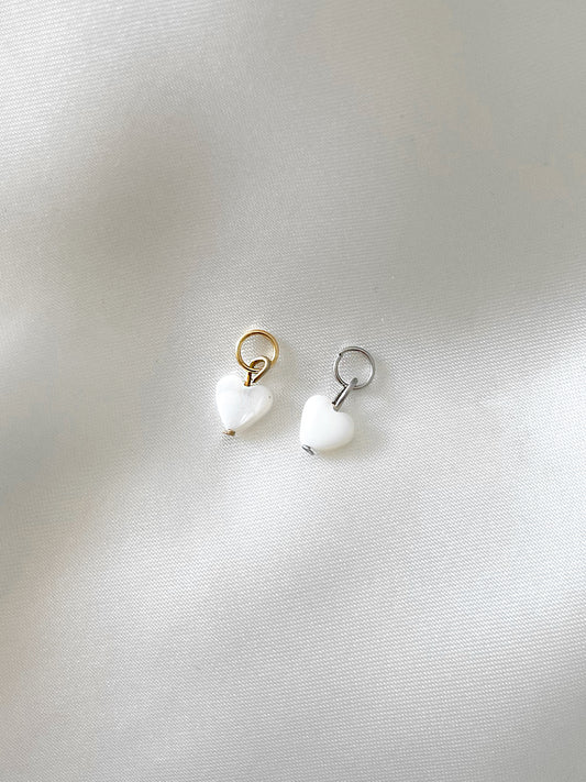 Unser Charm Anhänger ''Pearl Heart'' mit einer kleinen Muschel Perle in Herzform ist ein verspieltes Detail, das deinem Schmuckstück eine besondere Note verleiht.  Gefertigt aus Edelstahl und mit 18k Gold vergoldet, ist der Anhänger sowohl wasserfest als auch nickelfrei.  Er kann problemlos an all unsere Armbänder oder Ketten angebracht werden und ergänzt so dein Schmuckstück.